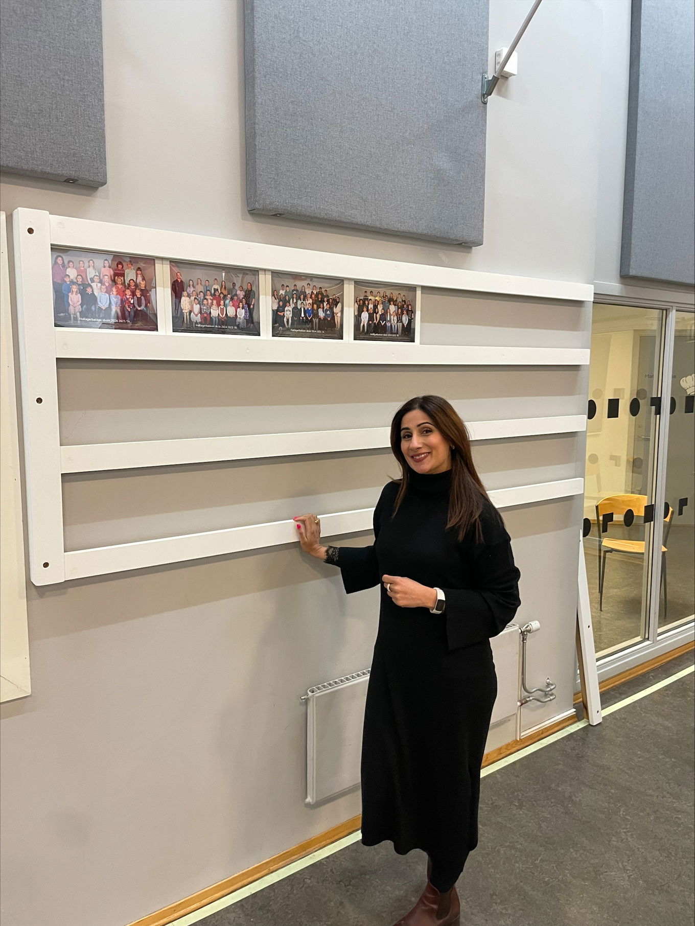 en person som står foran en vegg med bilder på