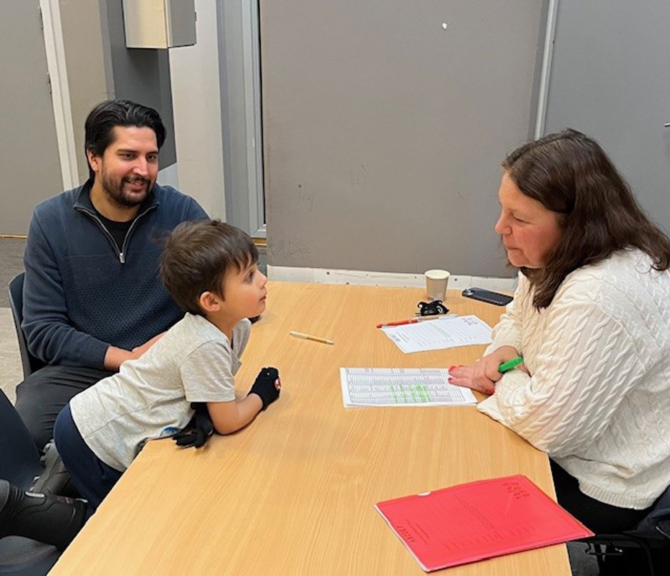 en person og en person og et barn som sitter ved et bord