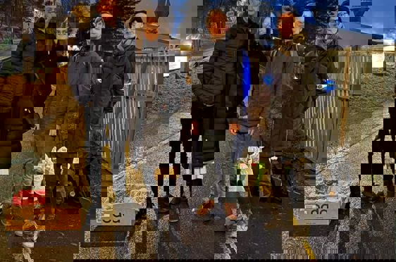 En gruppe mennesker som poserer for et bilde på en gate om natten