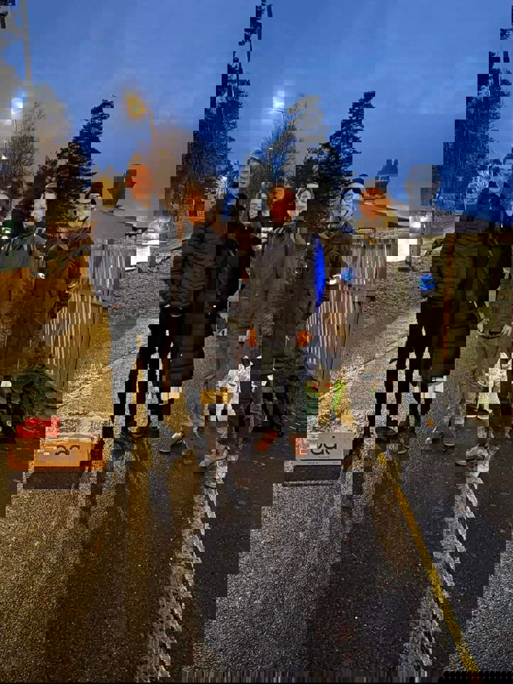 En gruppe mennesker som poserer for et bilde på en gate om natten