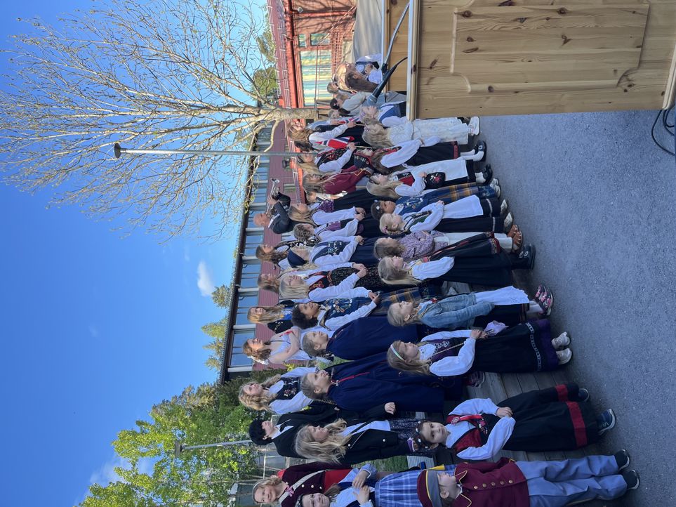 en gruppe mennesker som står på et fortau foran en bygning