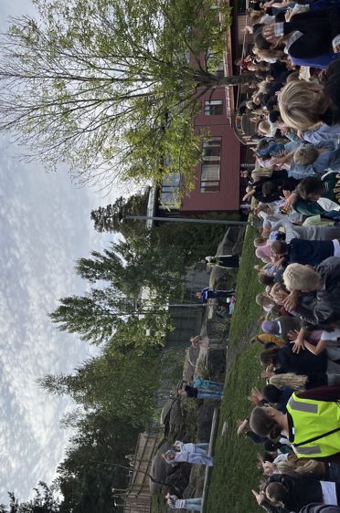 en gruppe mennesker som står på et fortau ved en vannmasse