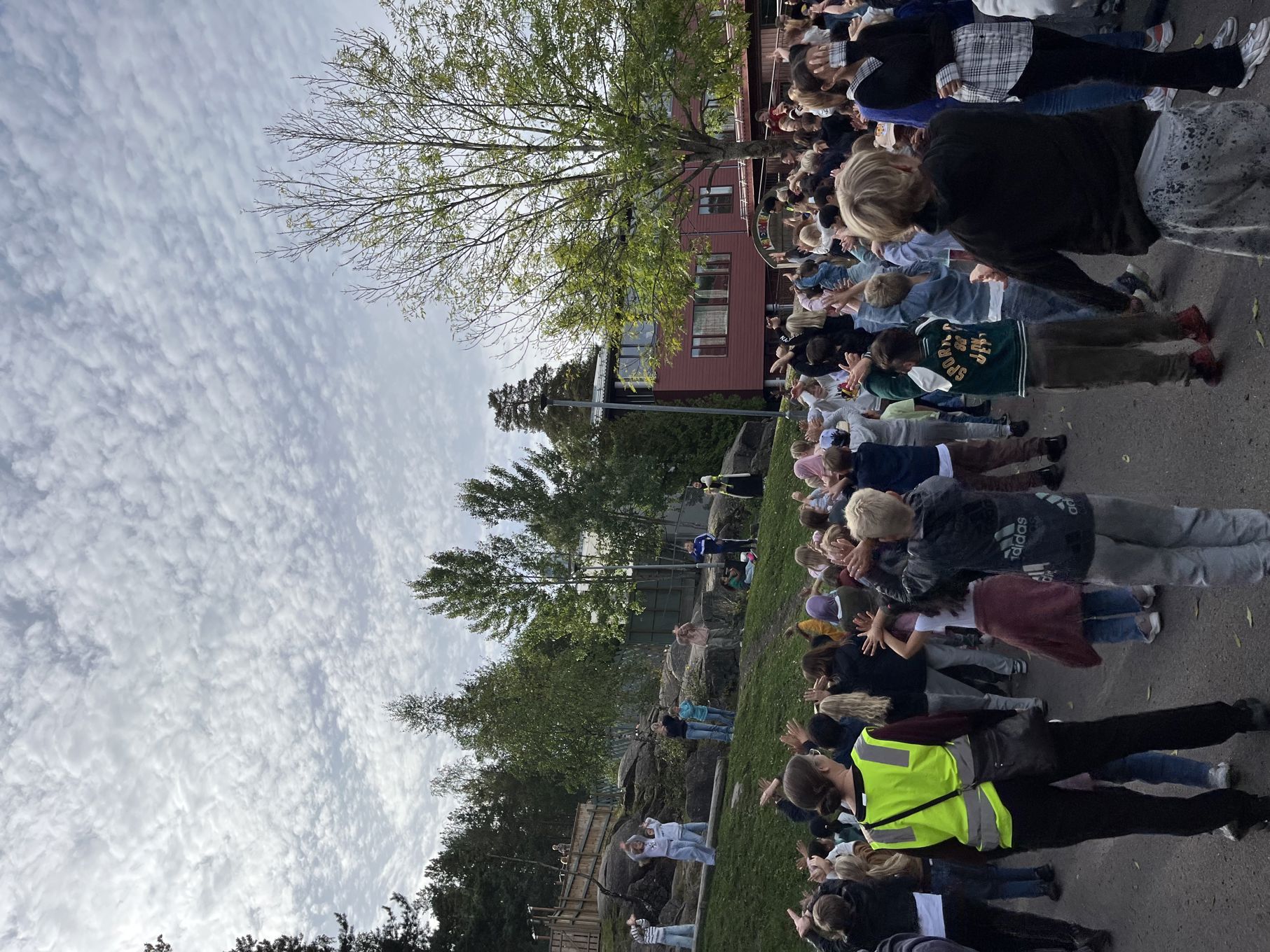 en gruppe mennesker som står på et fortau ved en vannmasse