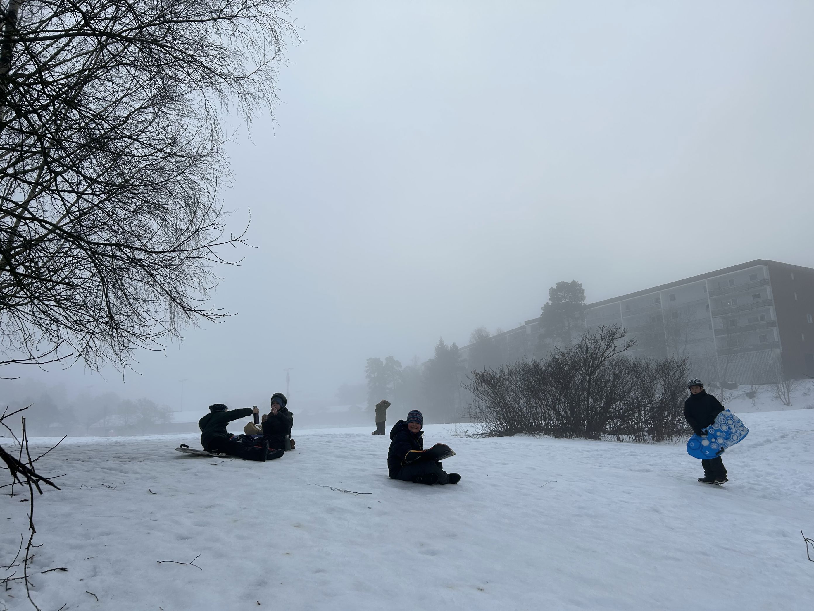 en gruppe mennesker som sitter i snøen