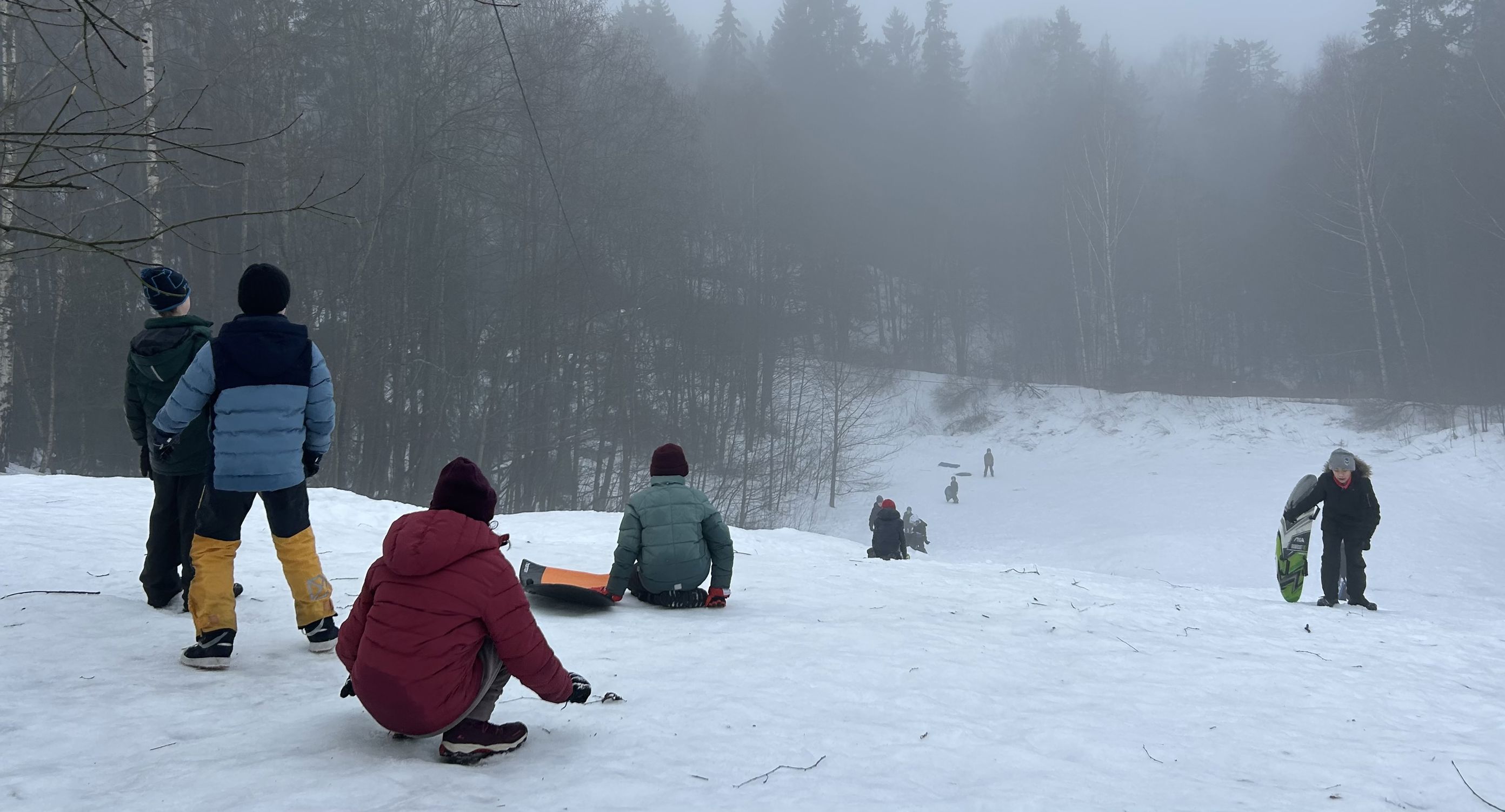 En gruppe mennesker står i snøen