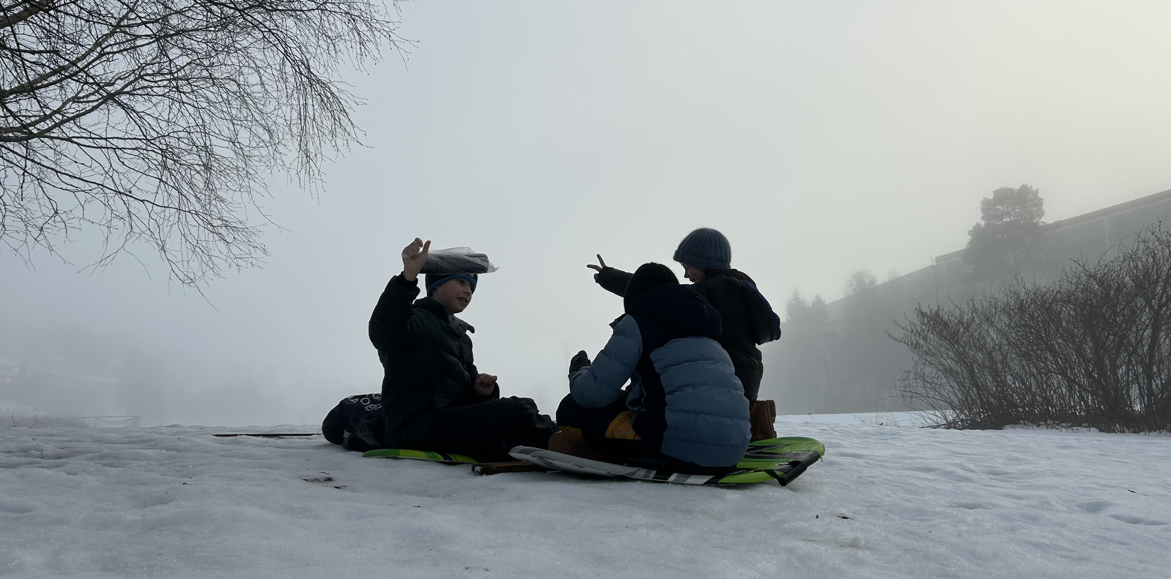 en gruppe mennesker som sitter i snøen