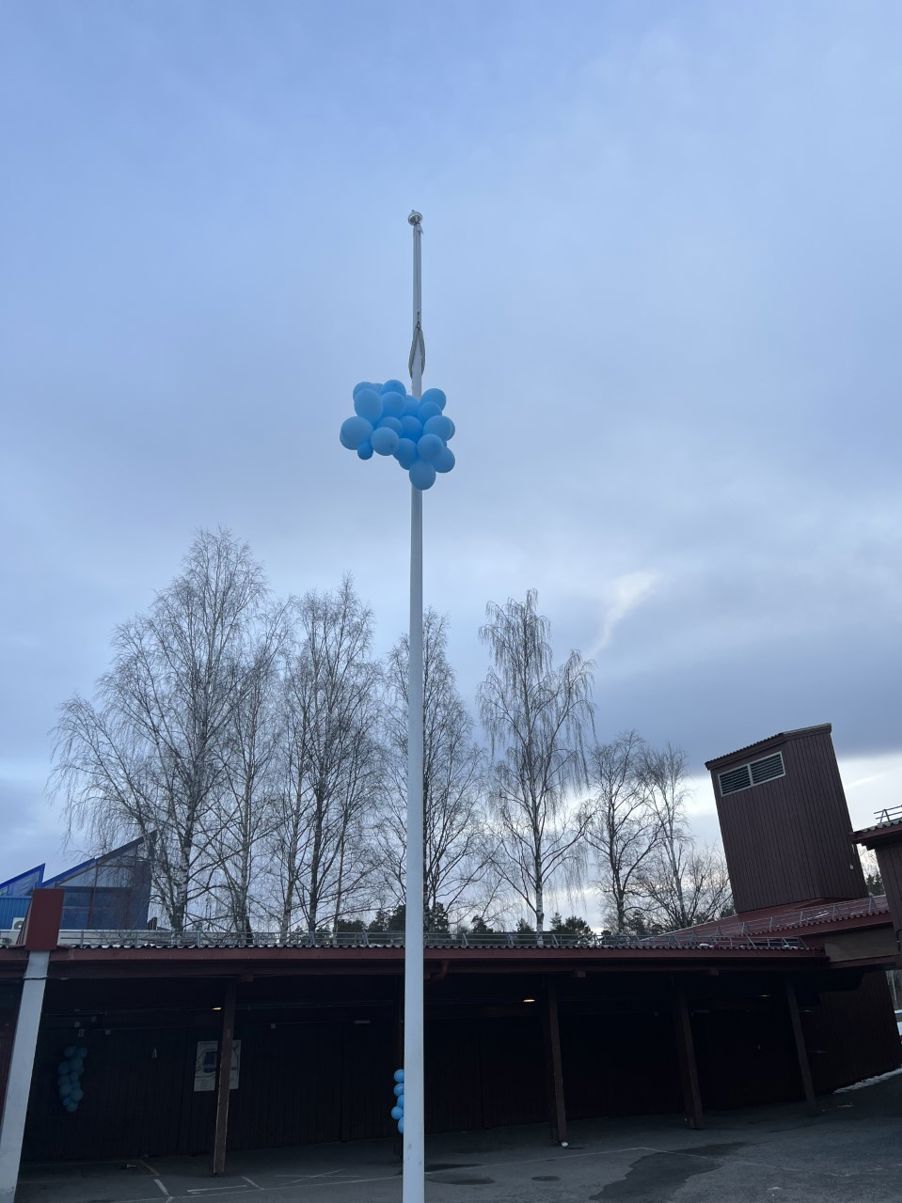 Blå ballonger i toppen av flaggstanga