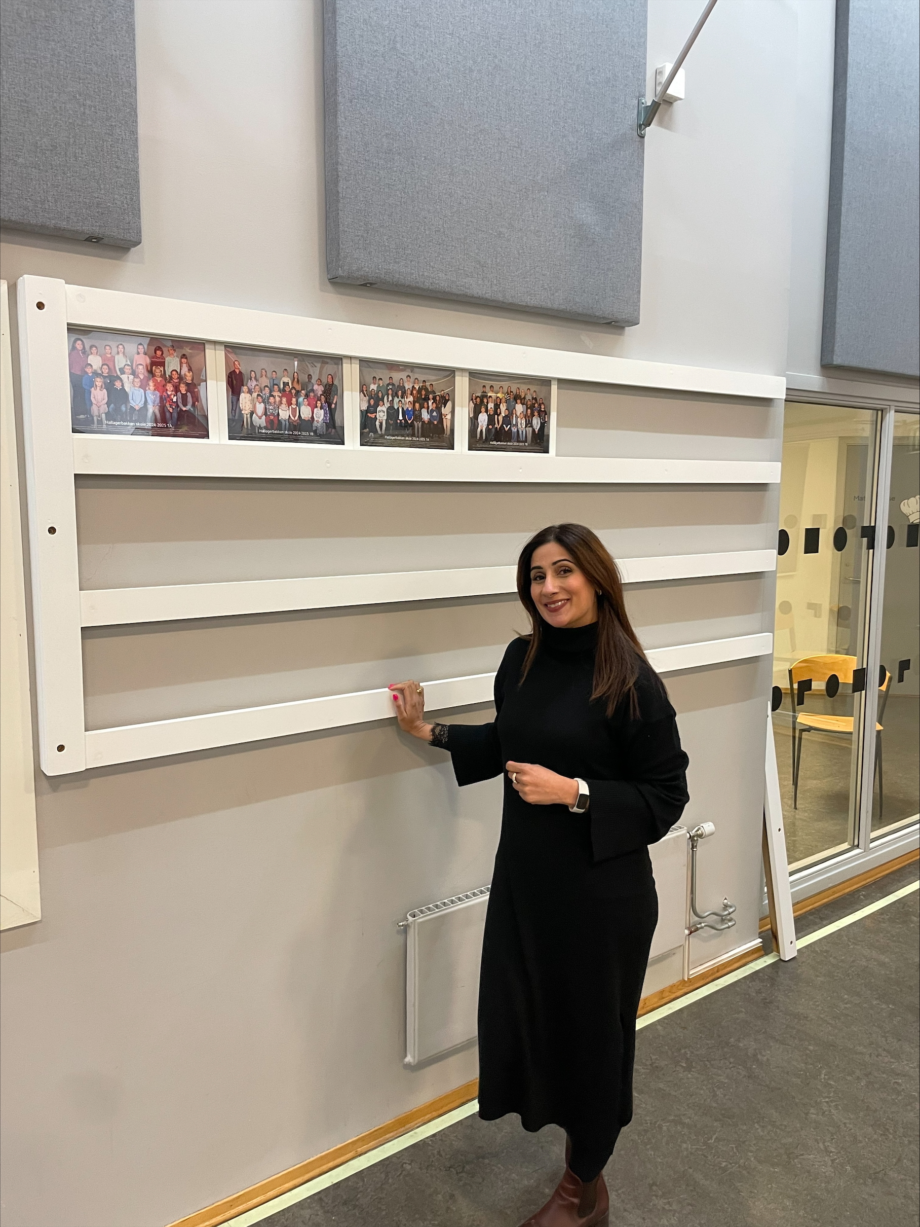 en person som står foran en vegg med bilder på