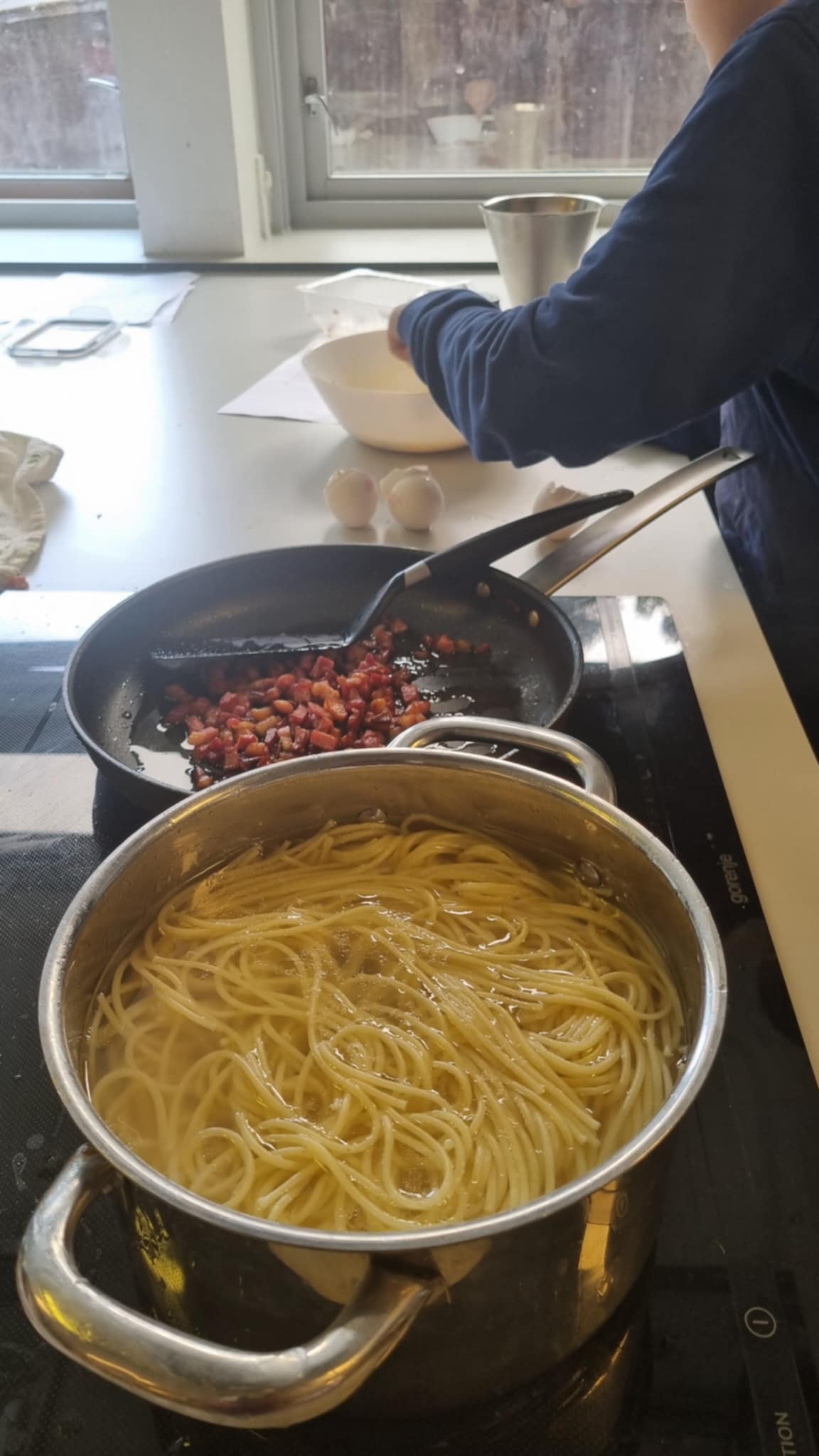 en person som lager mat i en panne