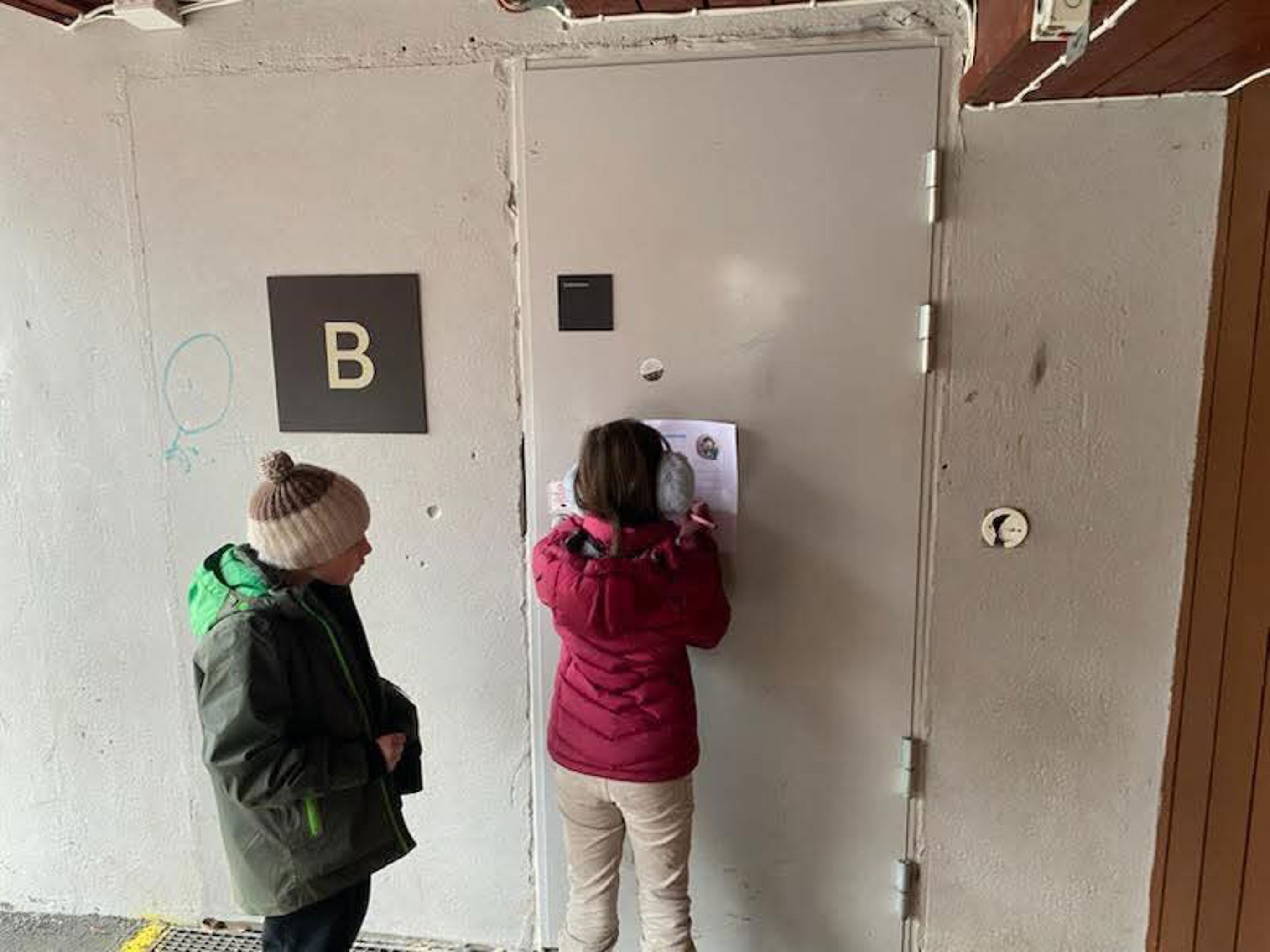et par barn som ser på en hvit dør